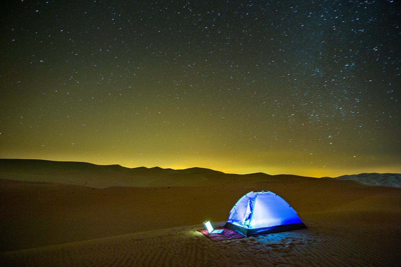 Liwa, Émirats Arabes Unis - Un ordinateur portable s'allume à l'extérieur d'une tente dressée sur les dunes du désert du quartier vide